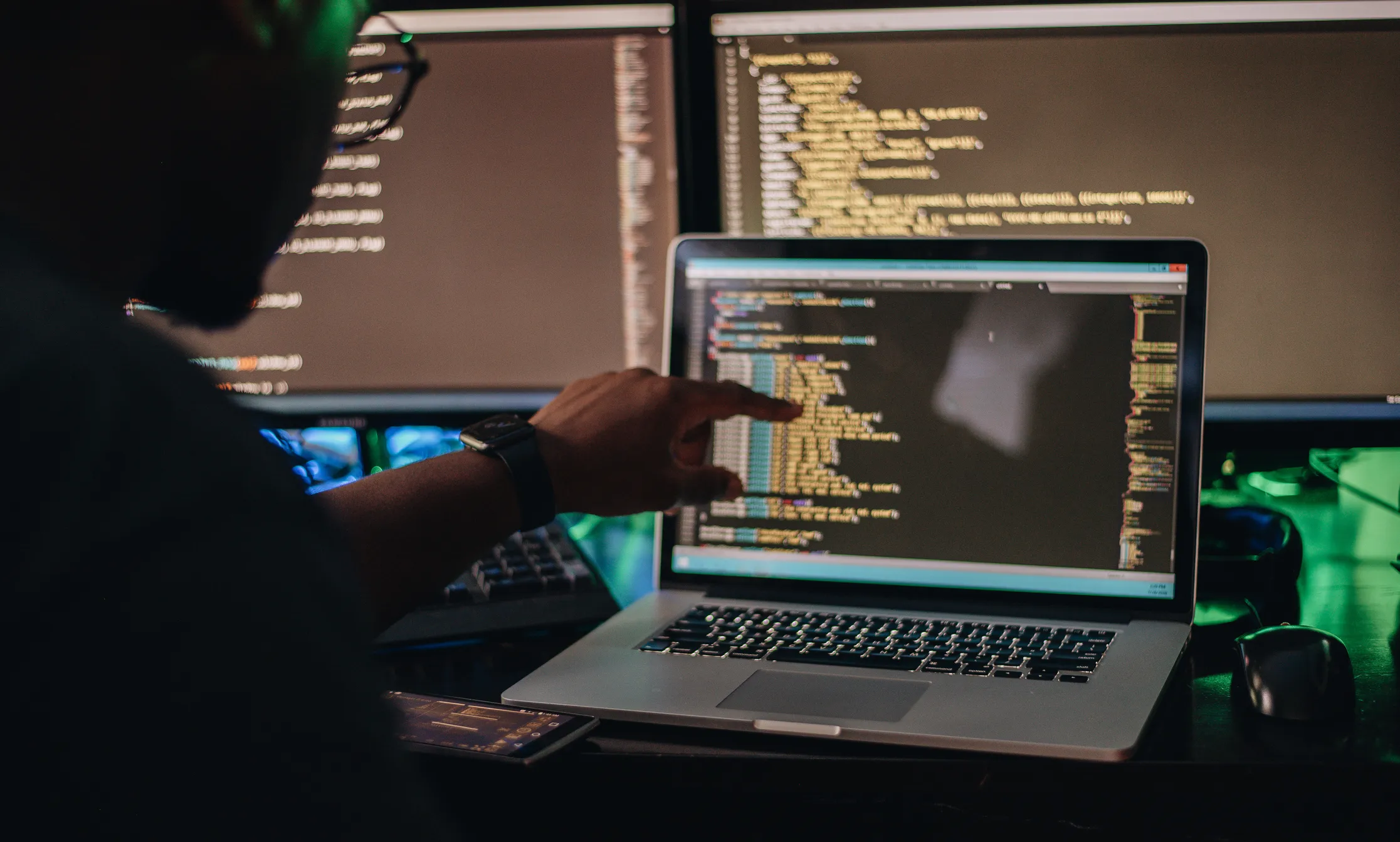 Black developer coding on laptop.