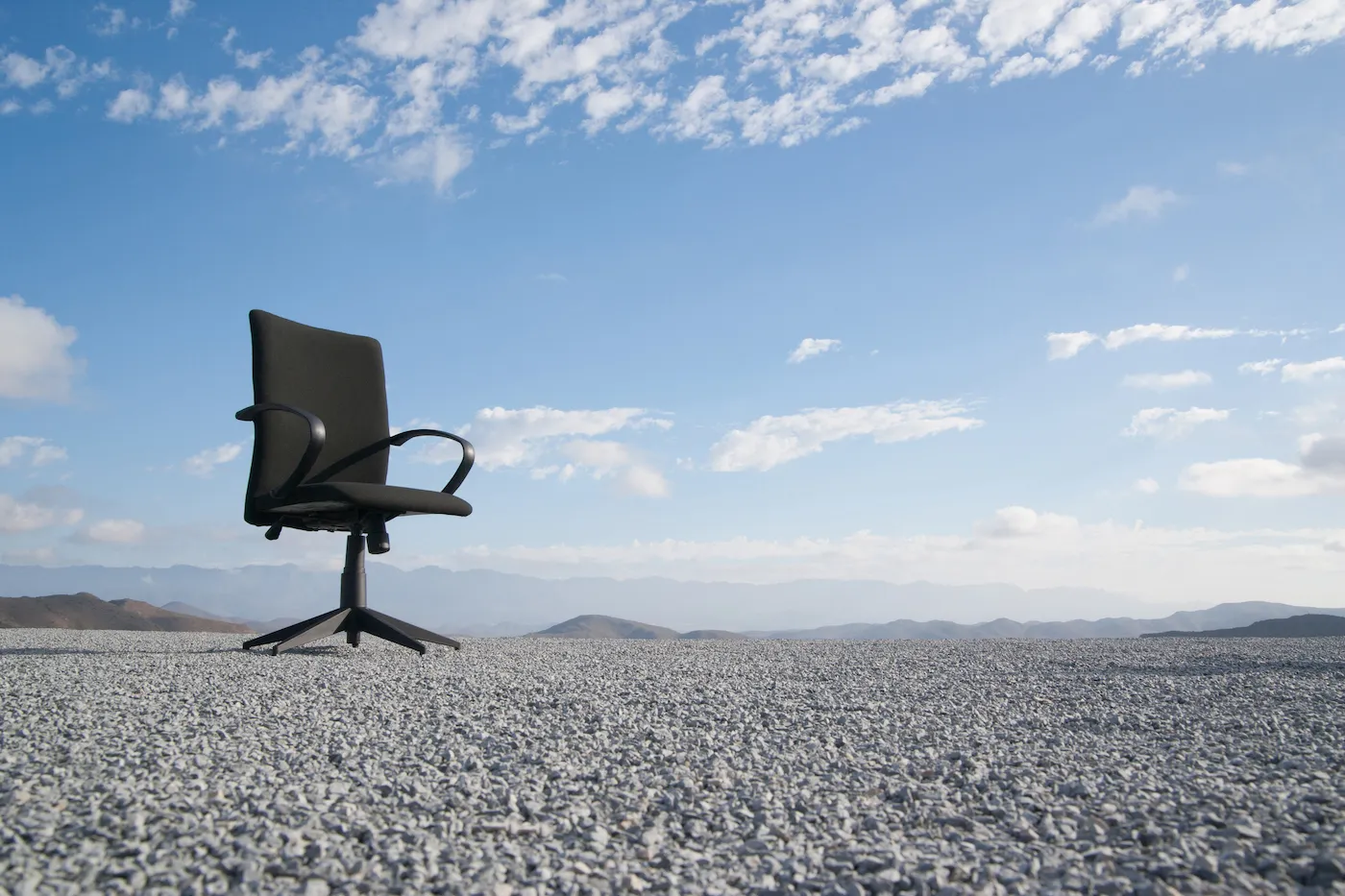 Office chair on a terrain full of pebbles
