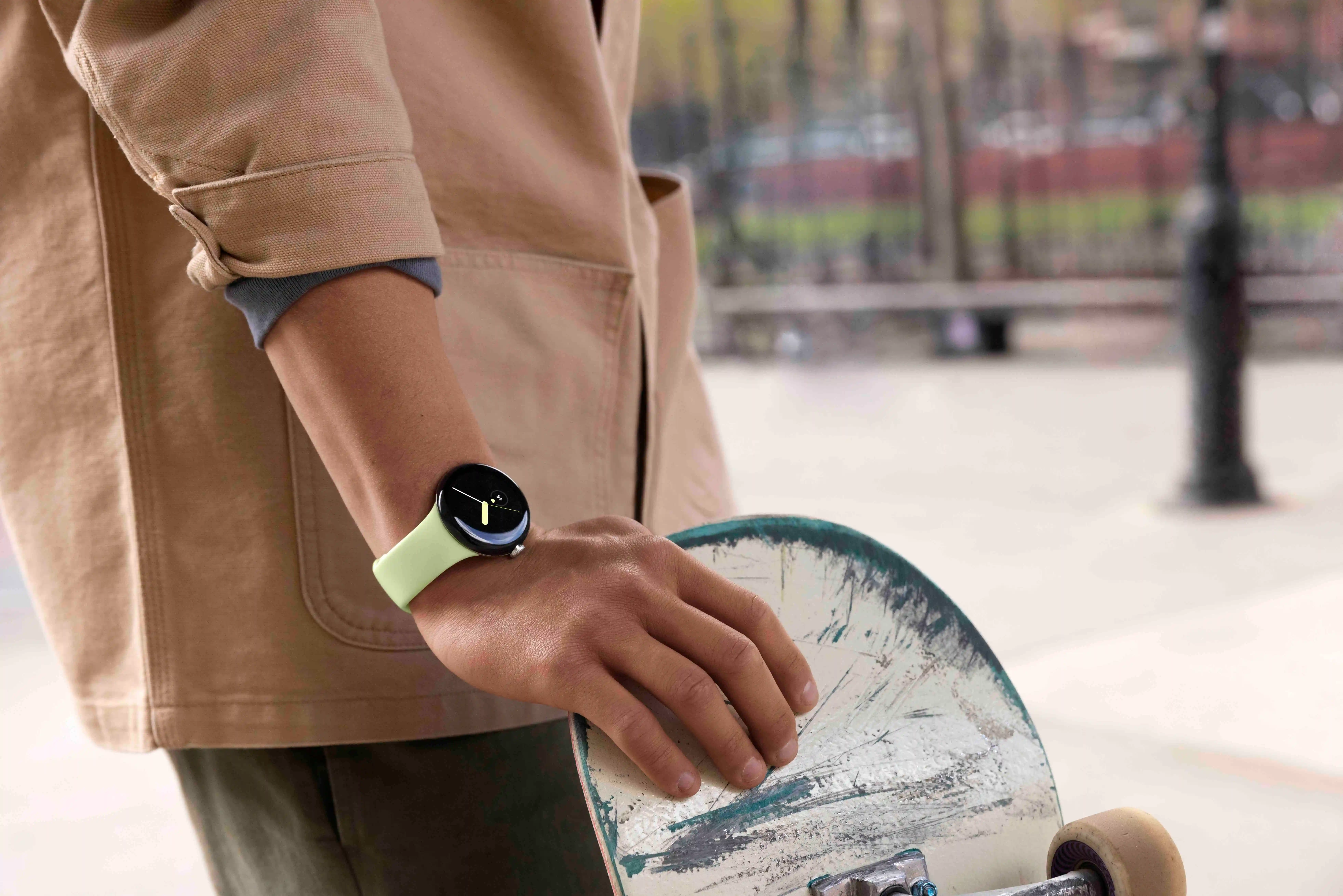 person wearing Google Pixel Watch, holding a skateboard