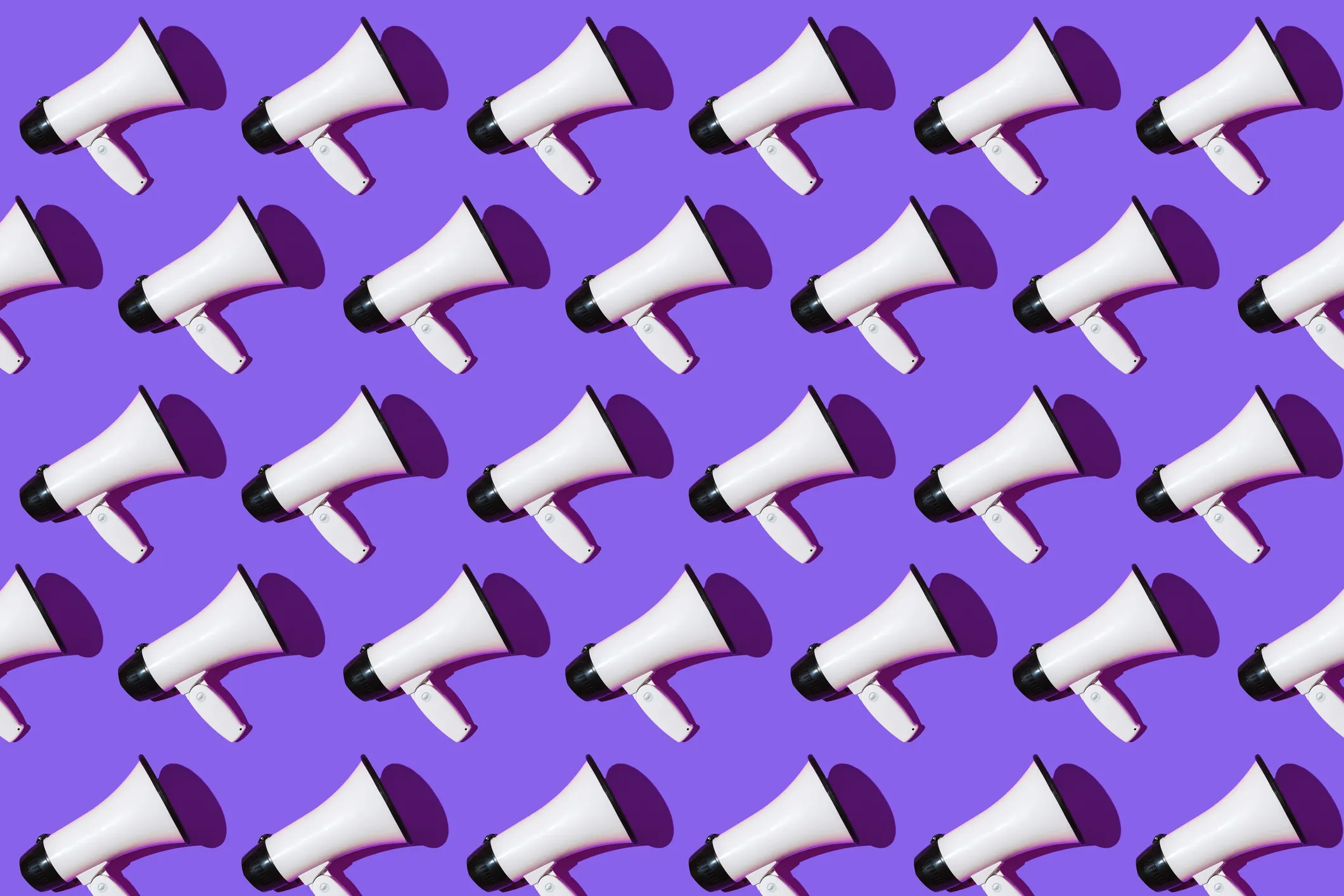 White megaphones pattern with black ornament on purple background. Shout, message, announcement and news concept.