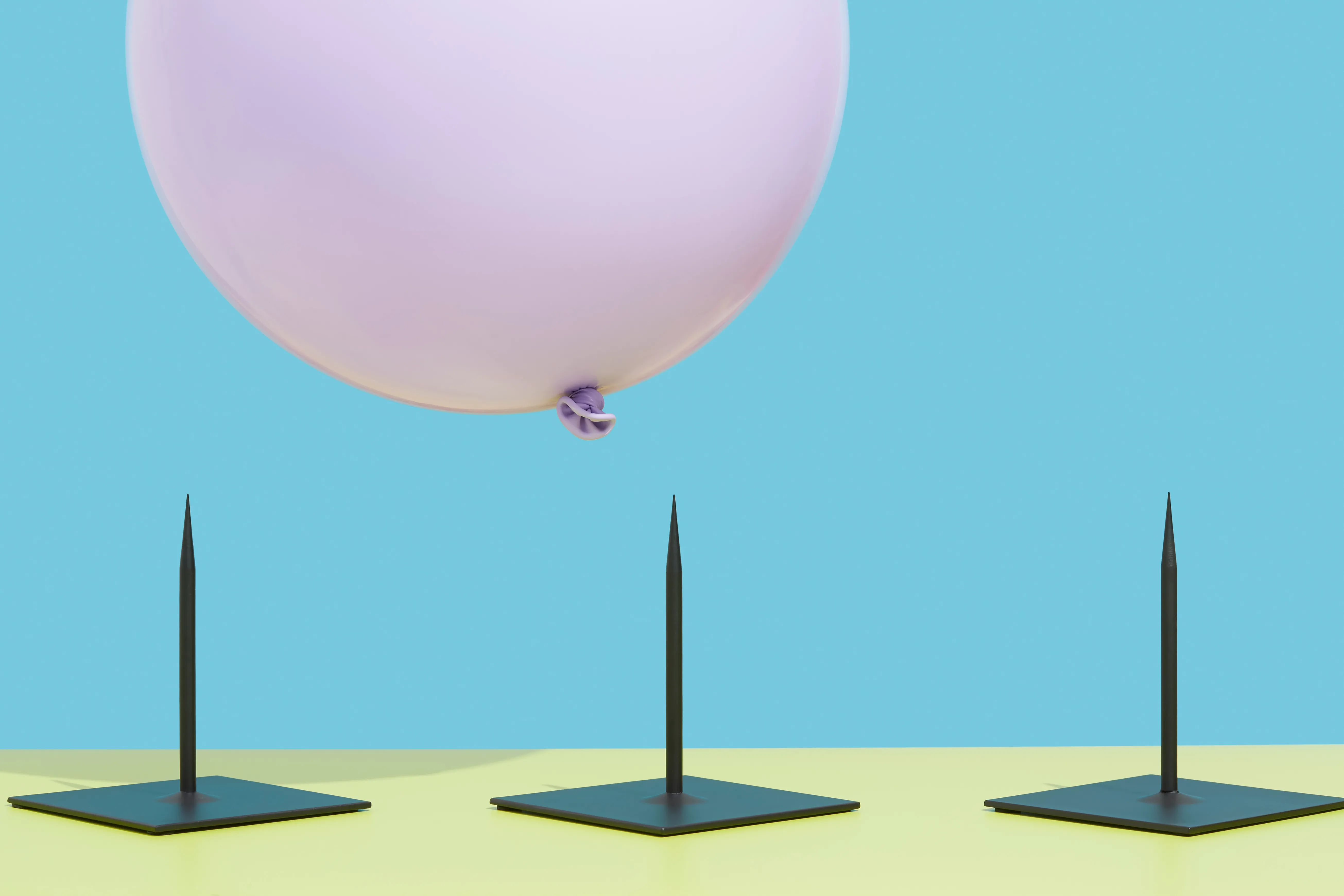 Image of a pink balloon hovering over three spikes to represent risk.