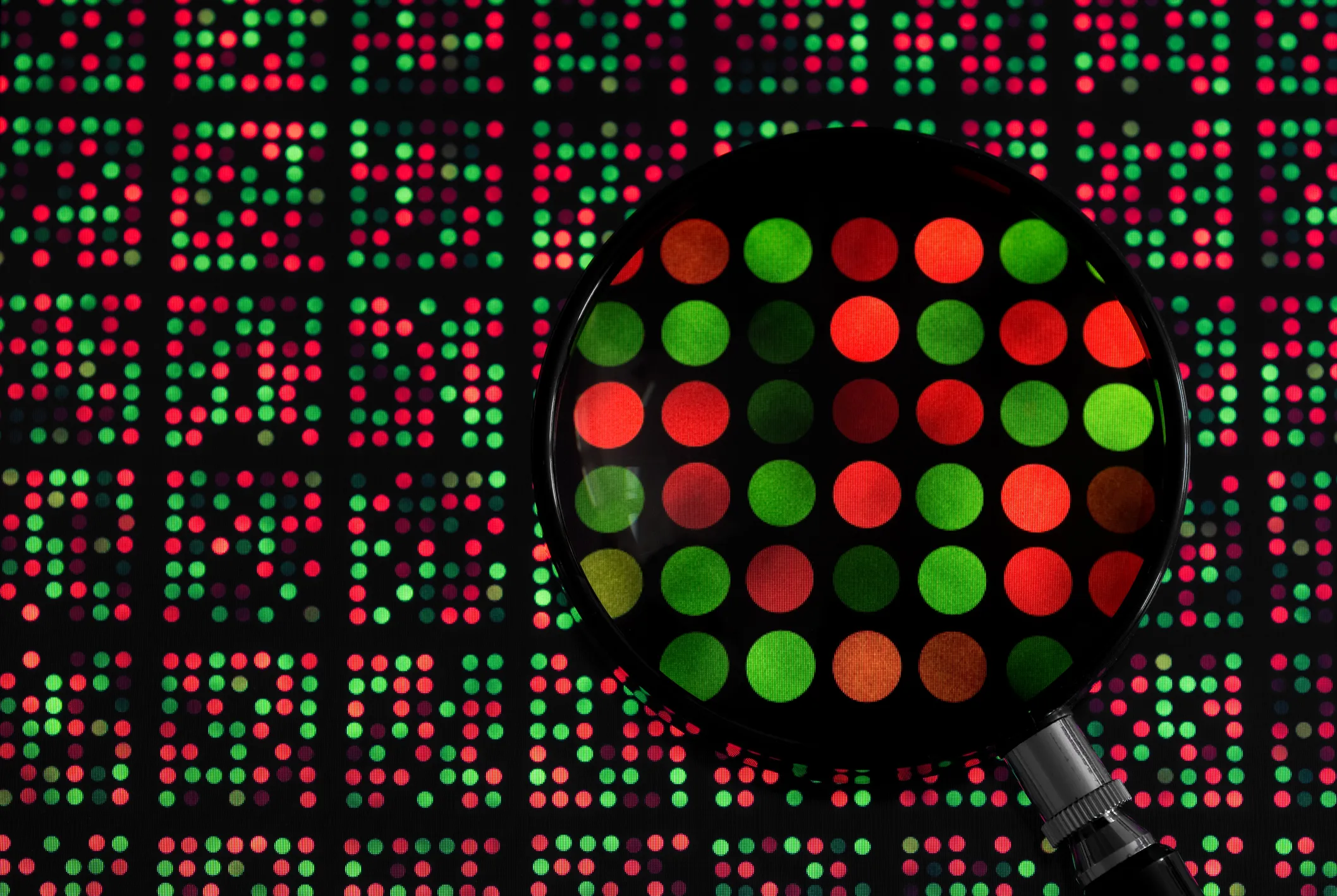 magnifying glass examining DNA chip