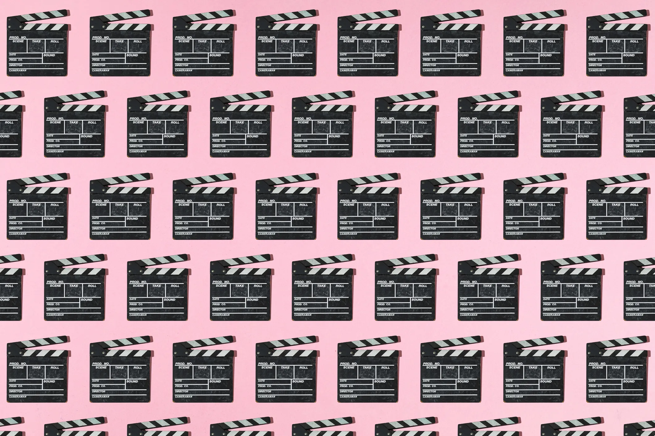 Wooden old movie clapperboard pattern with hard shadow on pink background. Concept of film industry, cinema, entertainment, and Hollywood.