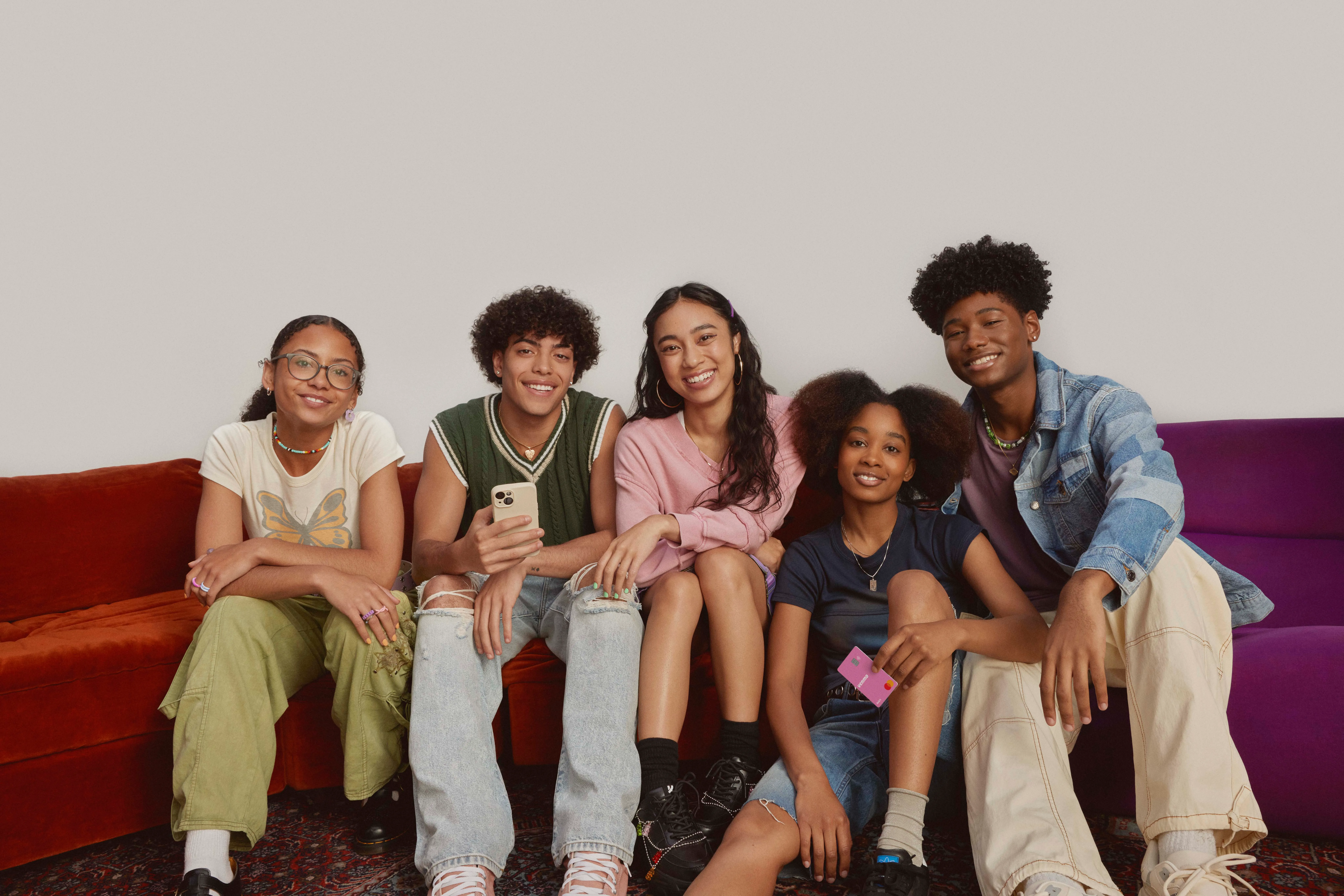 An image of four teenagers holding Venmo debit cards