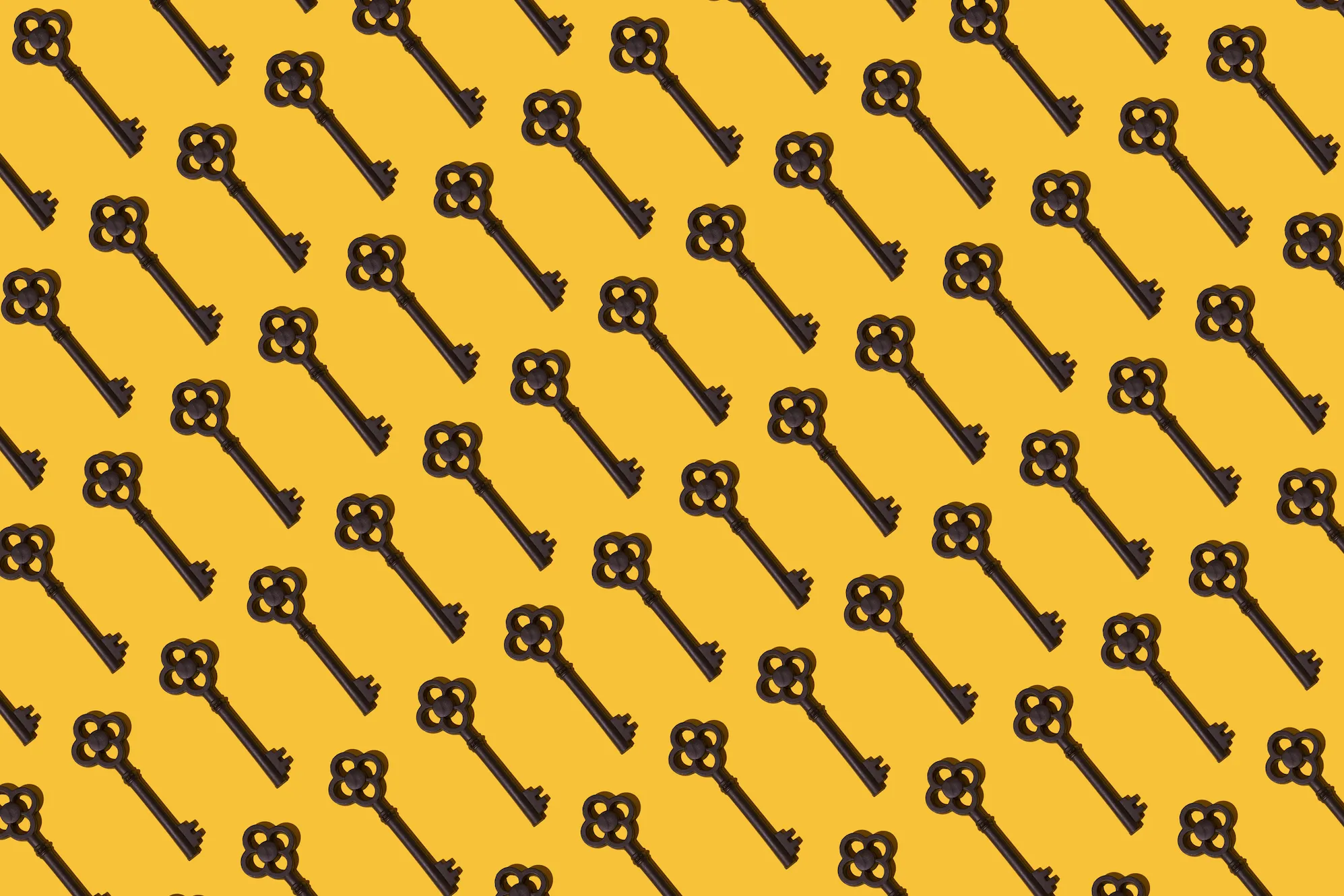 a pattern of antique keys on a yellow mustard background