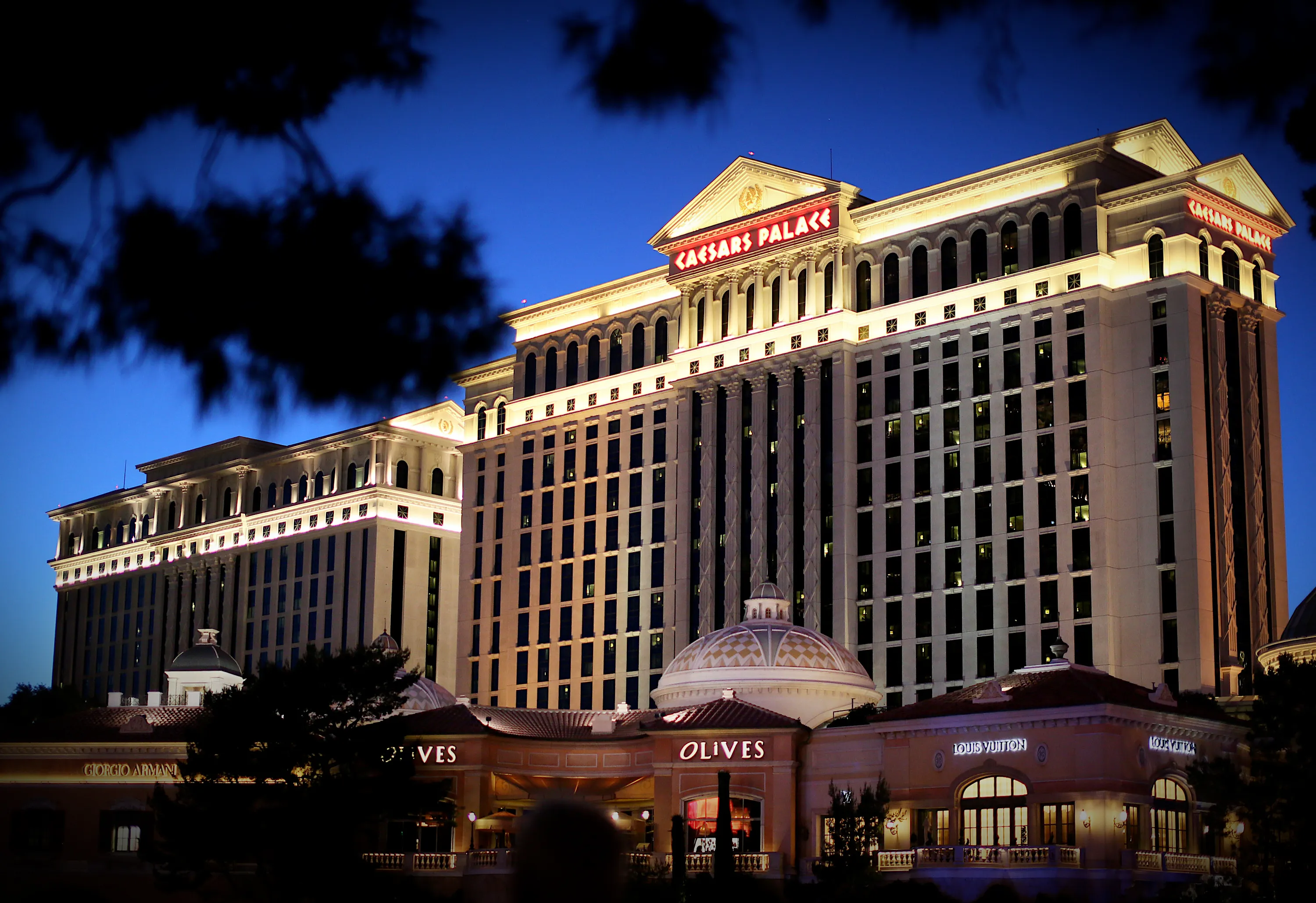 a photo of Caesars Palace Hotel sitting along Las Vegas Blvd, along the strip in Las Vegas, NV at night with the darkened sky