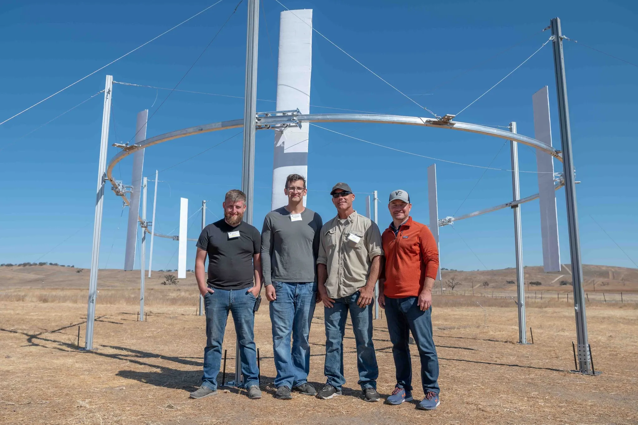 AirLoom team stand in front of a demo of their wind power installation.