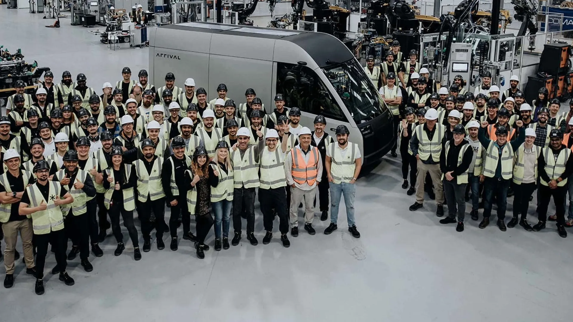 Arrival workers pose next to the company's first microfactory-built van.