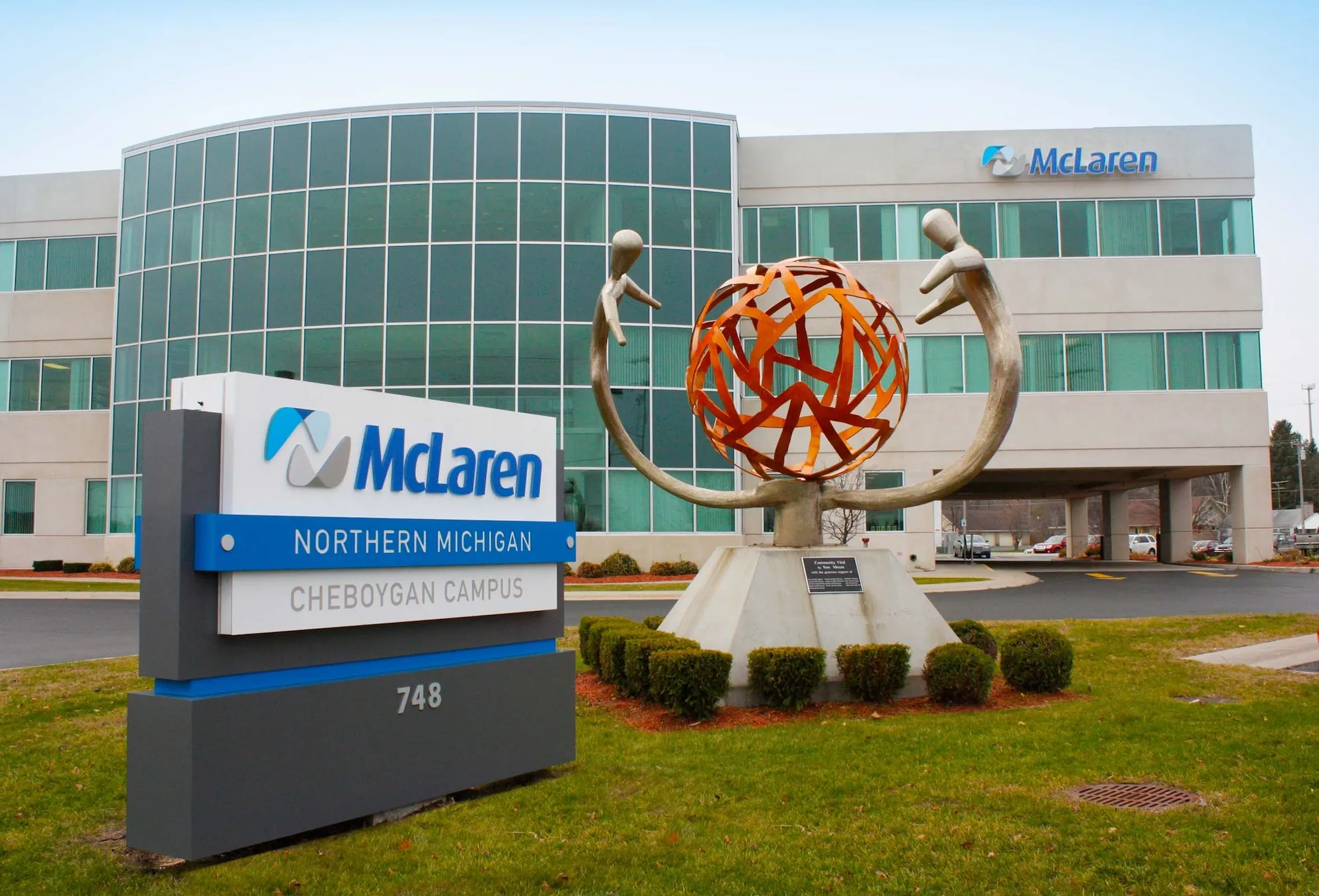 a photo of outside McLaren's hospital campus, showing a building in the background with a sign outside with McLaren's logo