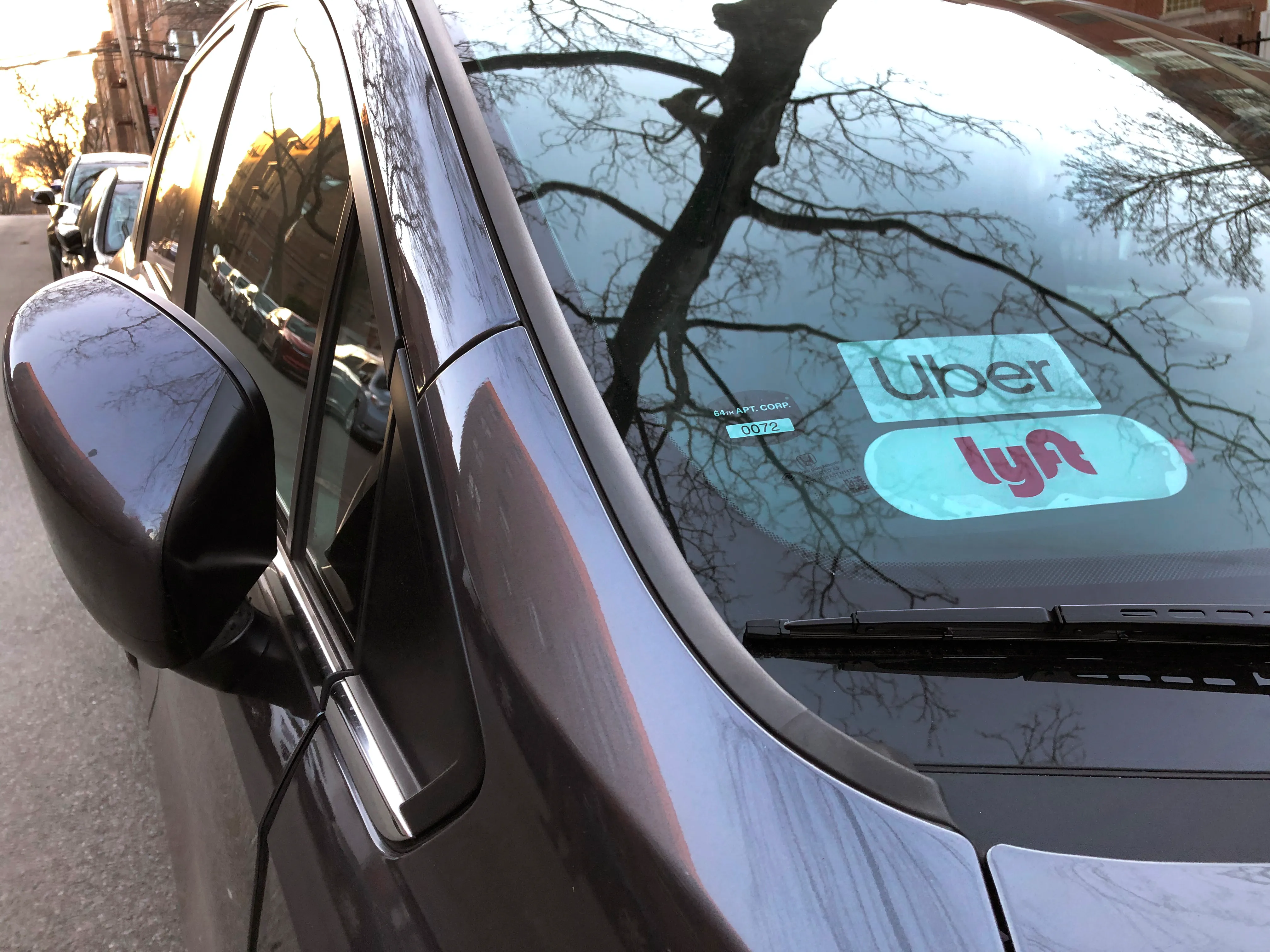 Uber and Lyft signs in windshield of car, Queens, New York.