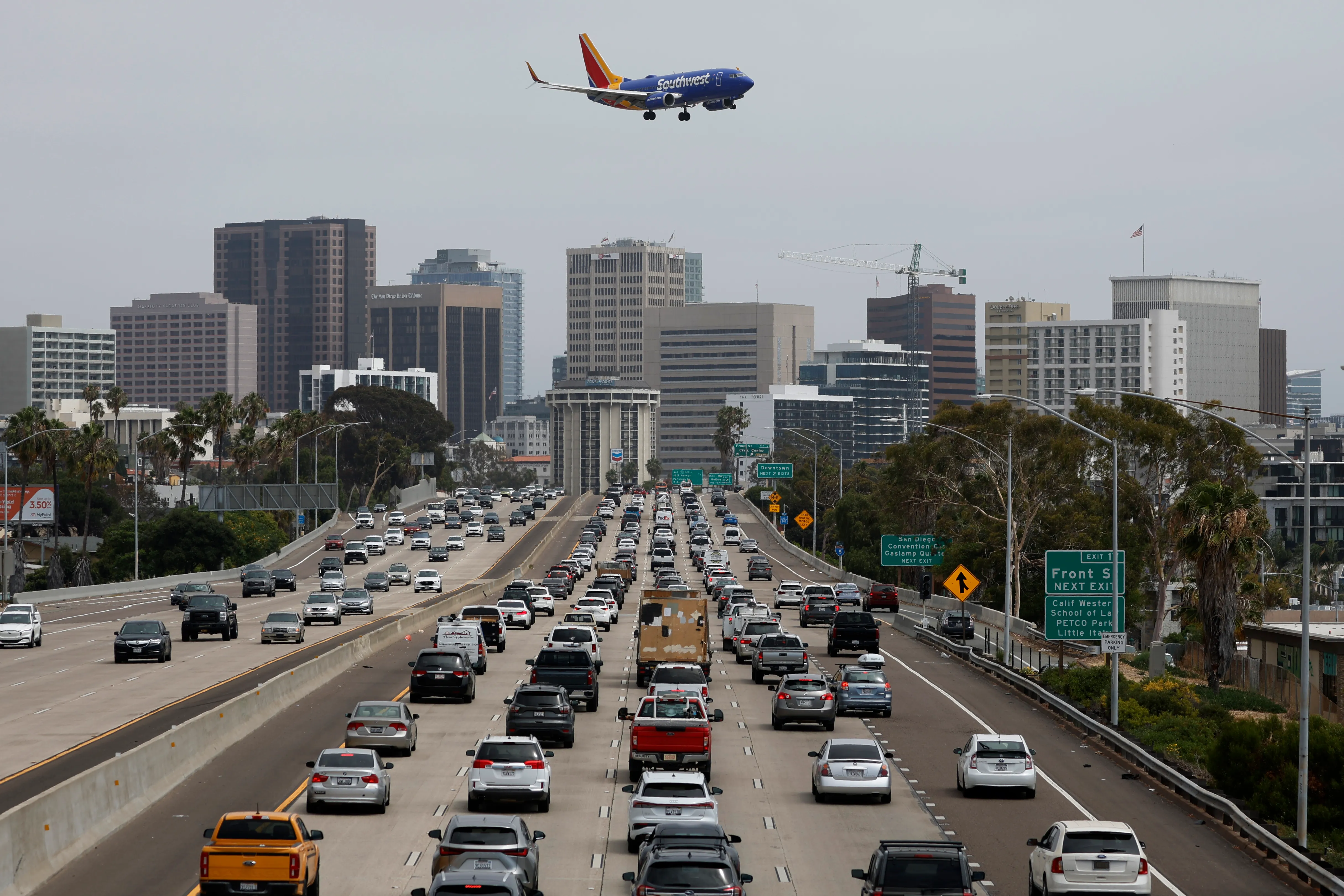 A Southwest Airlines Boeing 737-7H4 approaches San Diego International Airport for a landing from Houston as traffic on southbound Interstate 5 slows during the afternoon commute heading into downtown San Diego