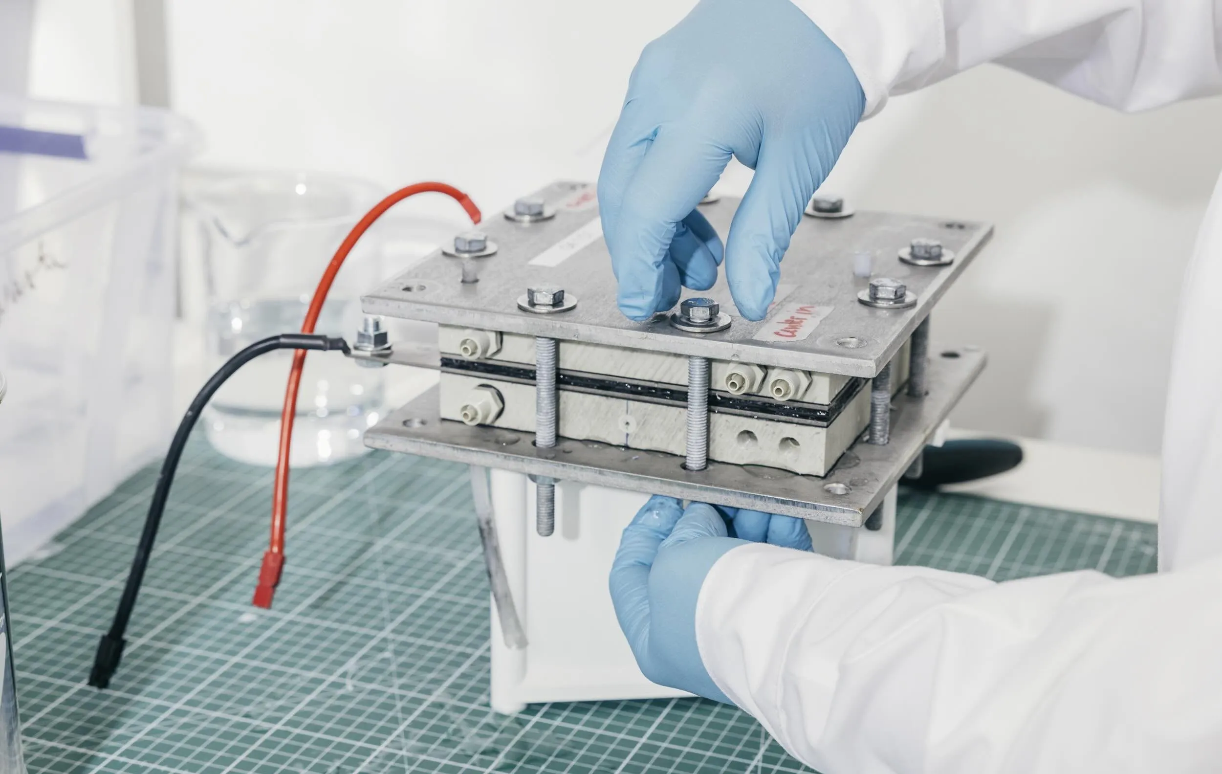 A lab technician seen close up working on a carbon dioxide removal device.