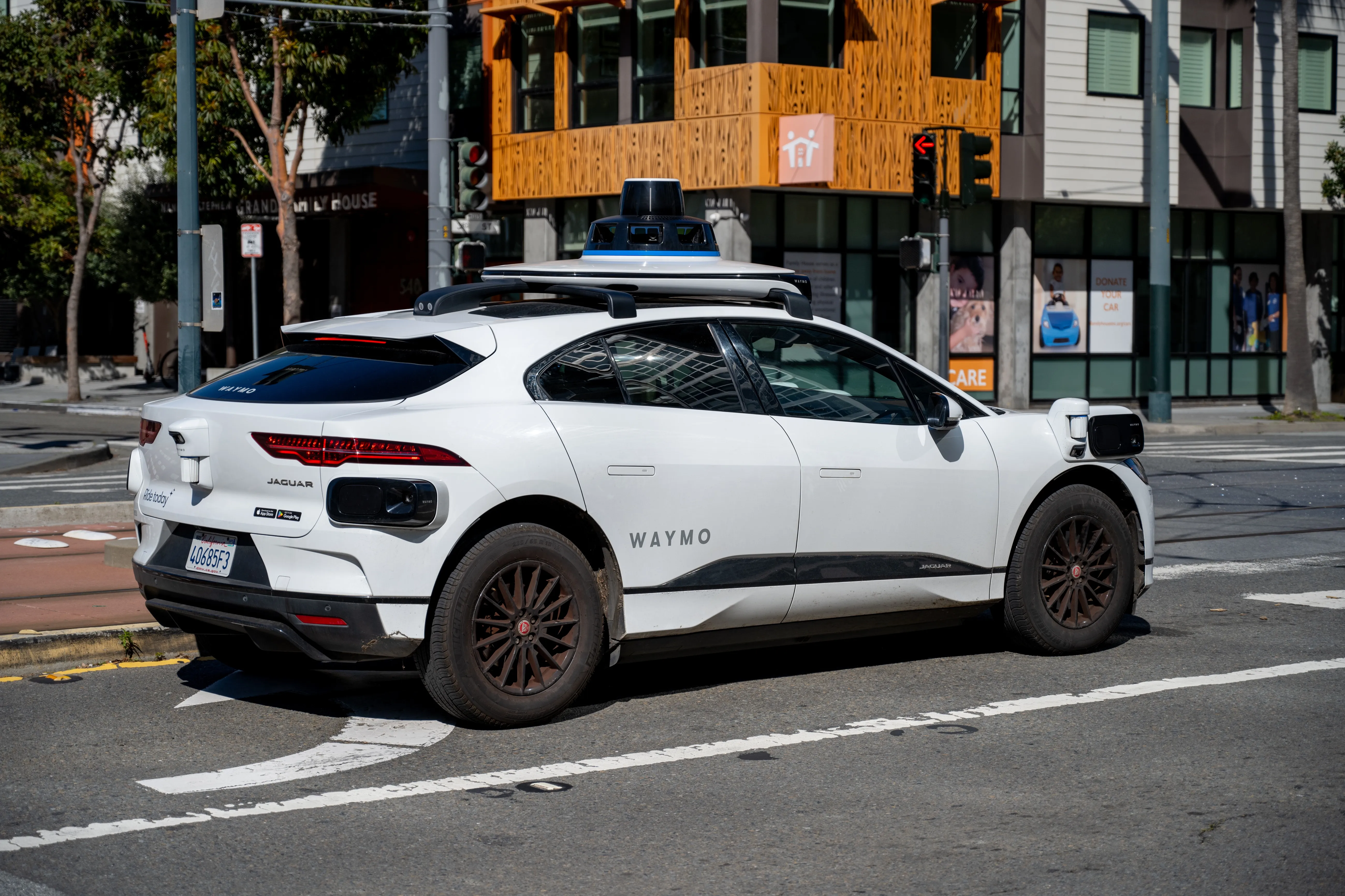 Waymo self driving car waiting at a city intersection in San Francisco