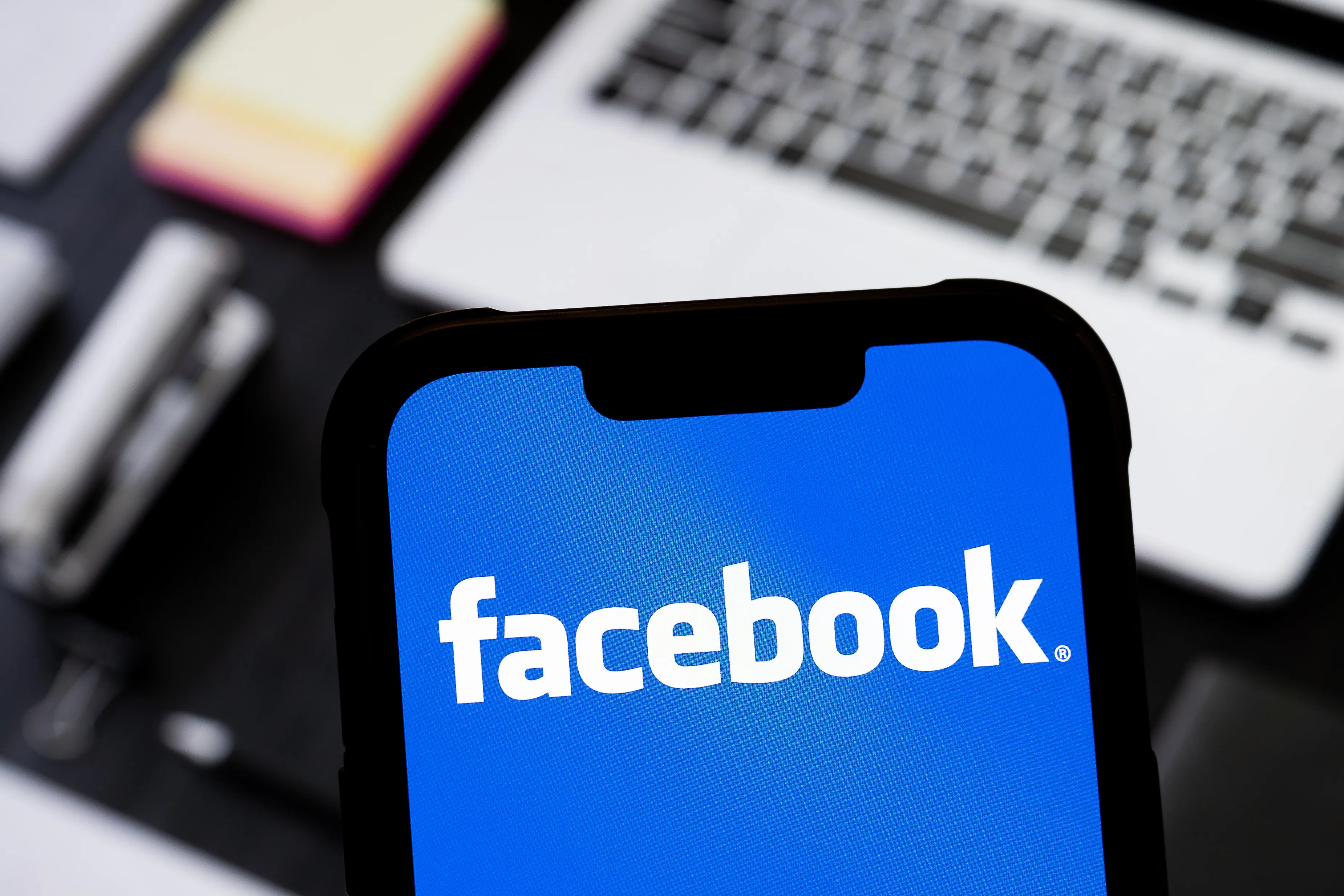 photo illustration of Facebook logo is seen displayed on a smartphone.