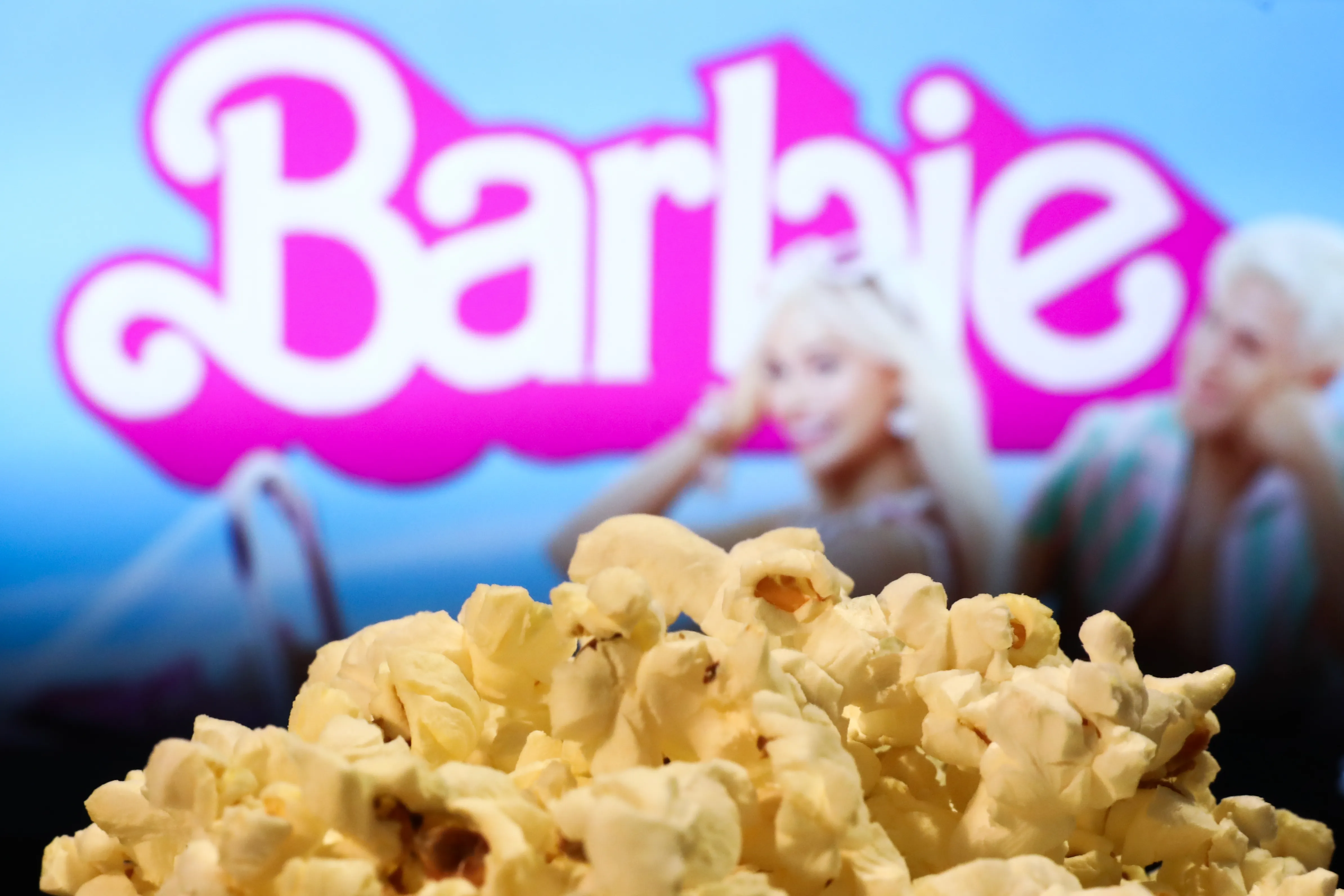 A popcorn and Barbie movie website displayed on a screen in the background are seen in this illustration photo taken in Krakow, Poland on August 1, 2023.