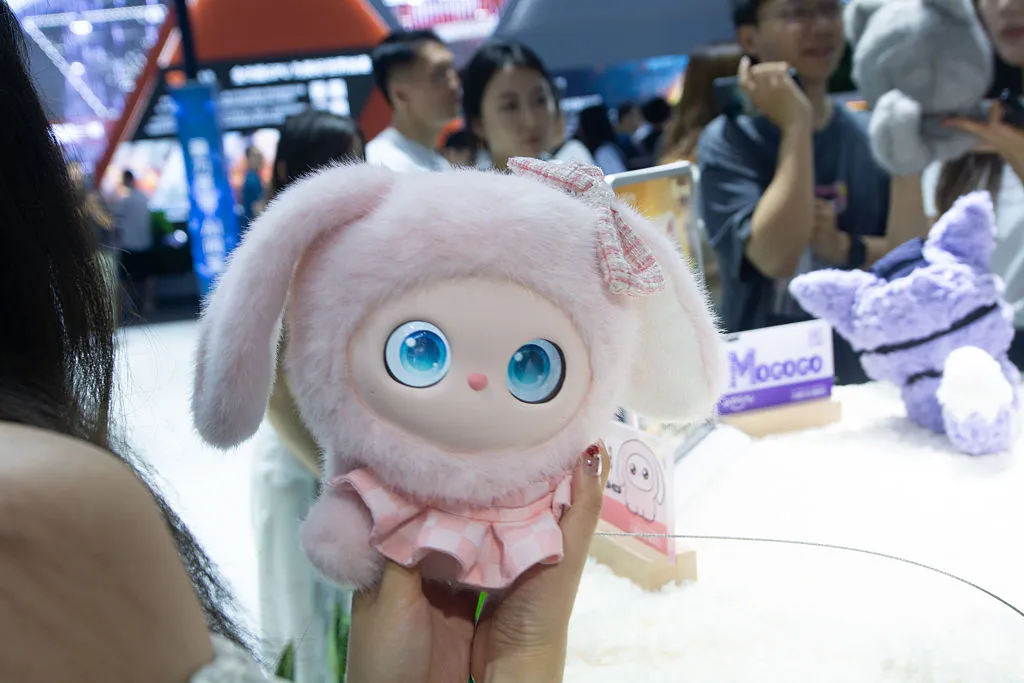 A general view shows fairgoers playing with an interactive doll at the Nubia booth at the Shanghai New Expo Center during the opening day of the World Artificial Intelligence Conference (WAIC) 2025 in Shanghai, China