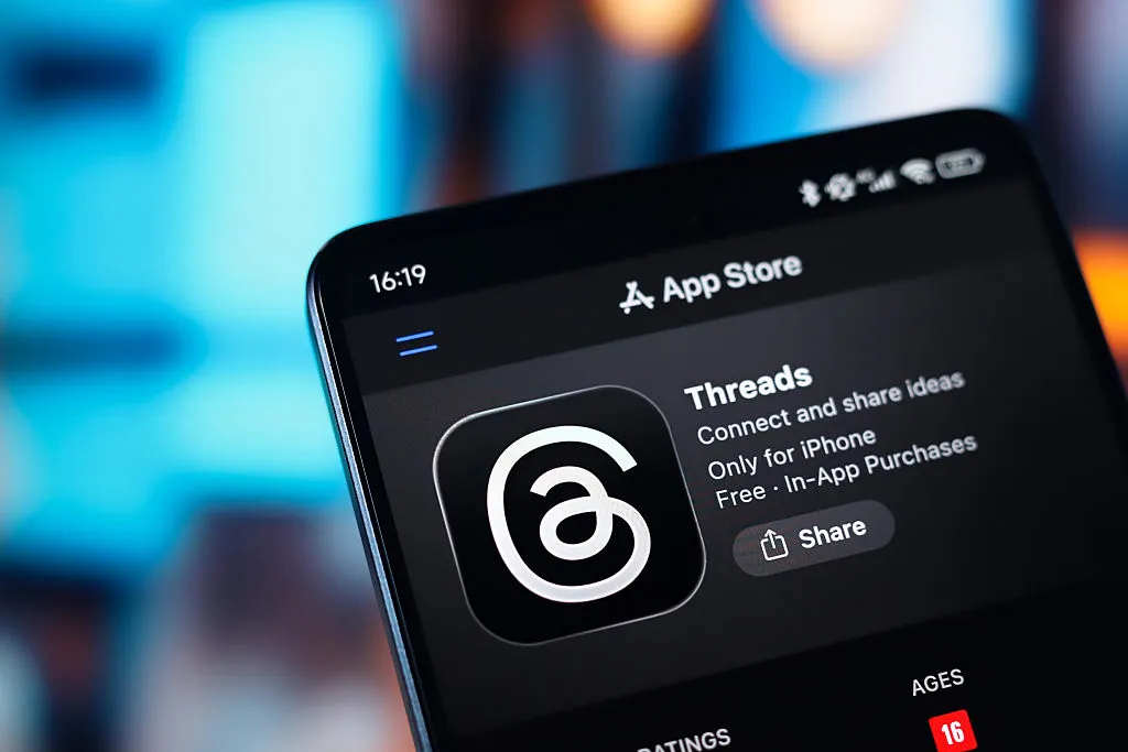 The Threads logo appears on a smartphone screen in the Apple app store in this photo illustration